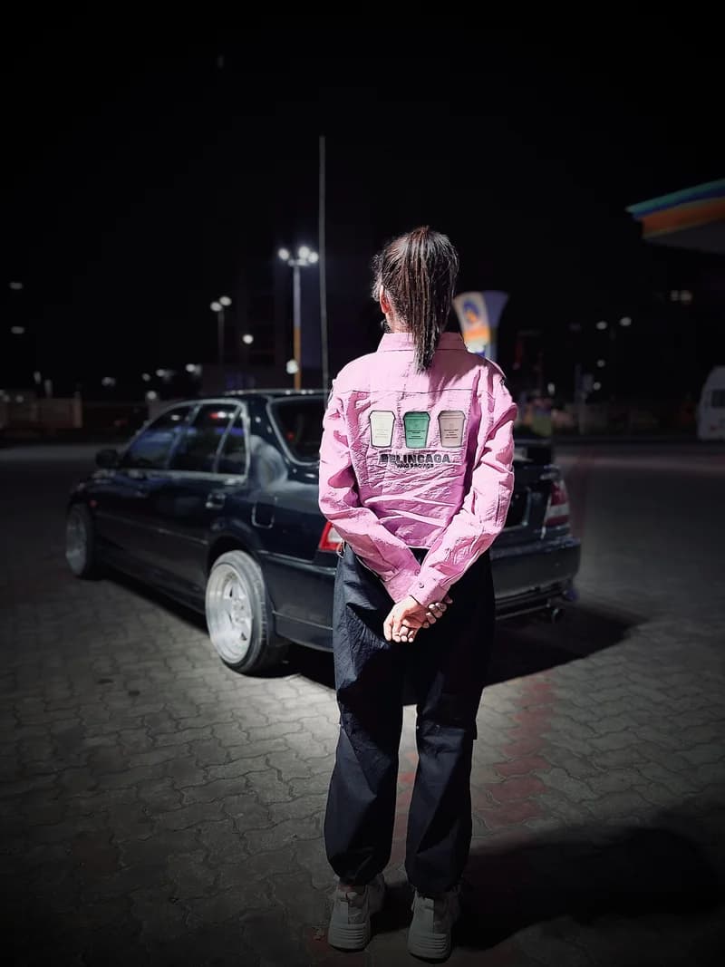 Night source photograph of an owner facing away beside a dark Honda City.
