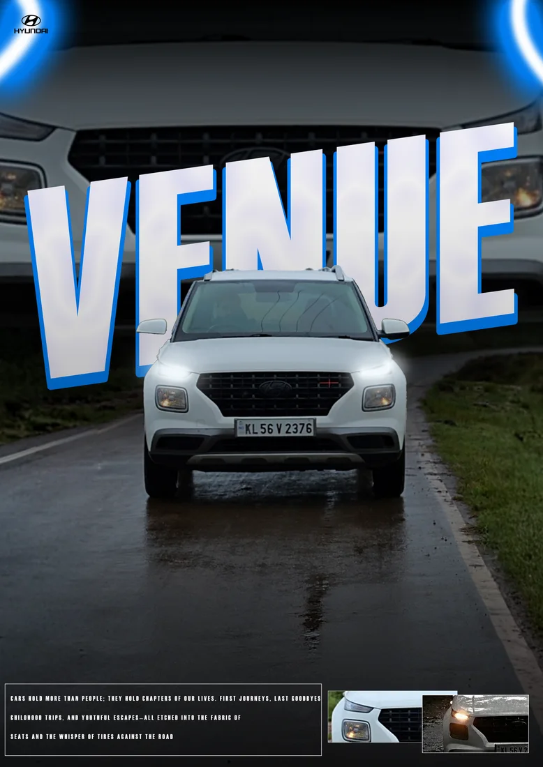 White Hyundai Venue on a wet road with white/blue VENUE lettering and grille backdrop.