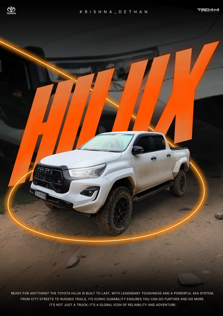 White Toyota Hilux pickup with orange HILUX lettering and orange light ring.
